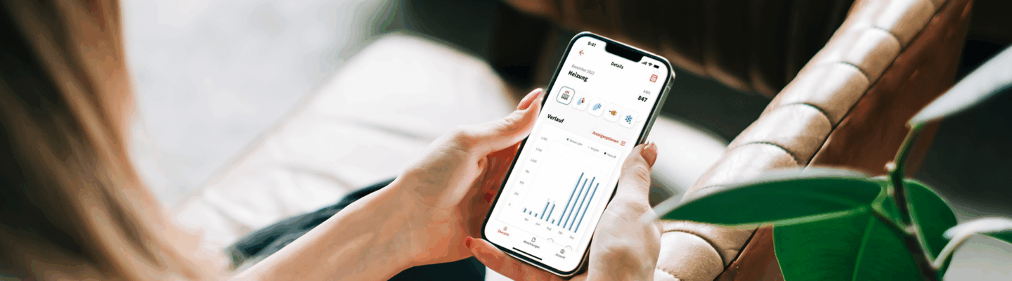 Frau schaut sich auf Smartphone die Minol App an
