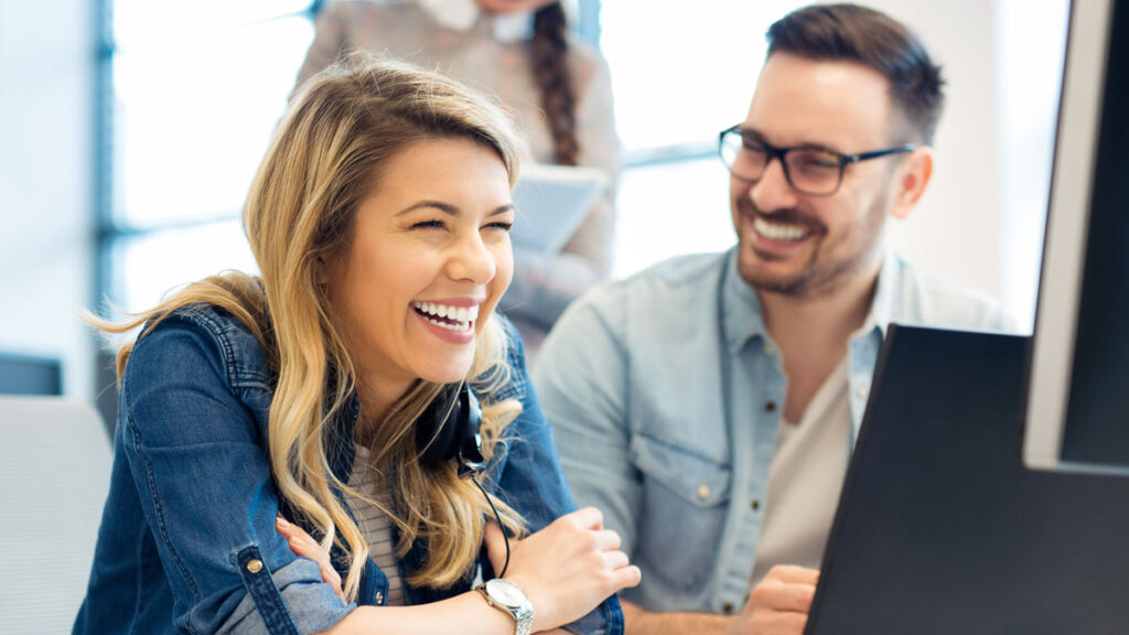 Ein Mann und eine Frau vor dem Monitor