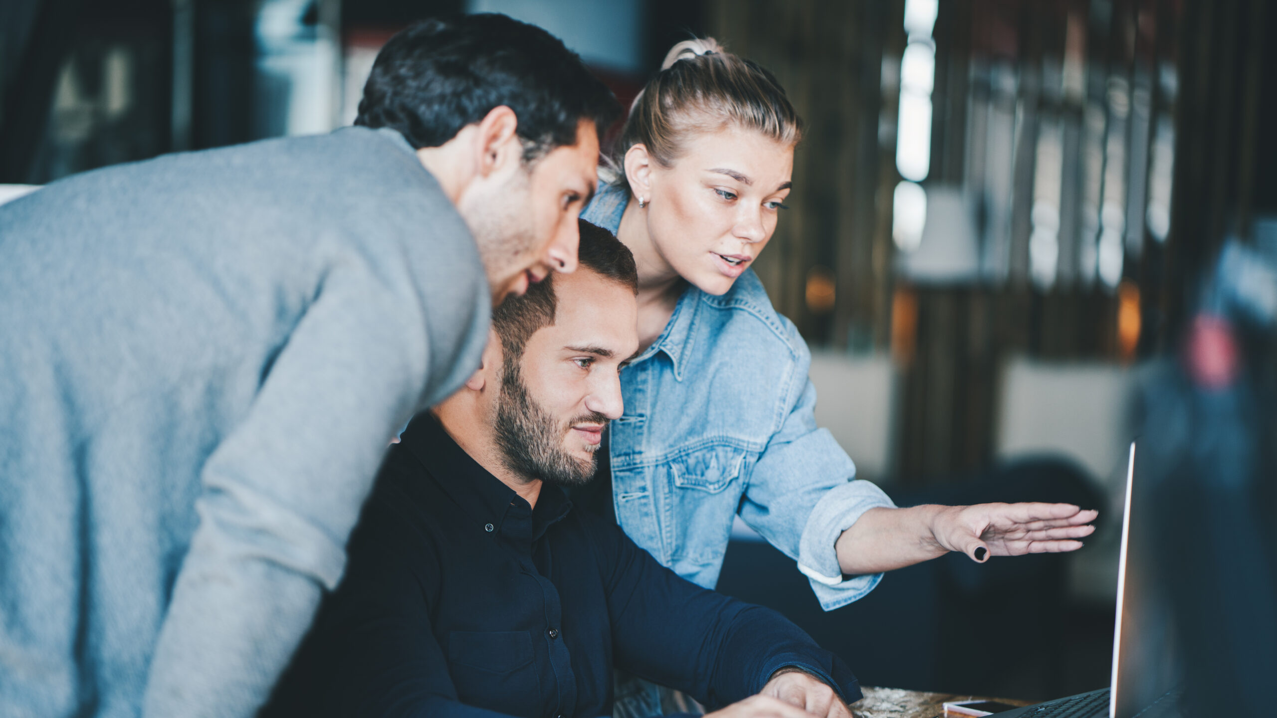 Eine Gruppe Menschen schaut auf einen Bildschirm und analysiert.