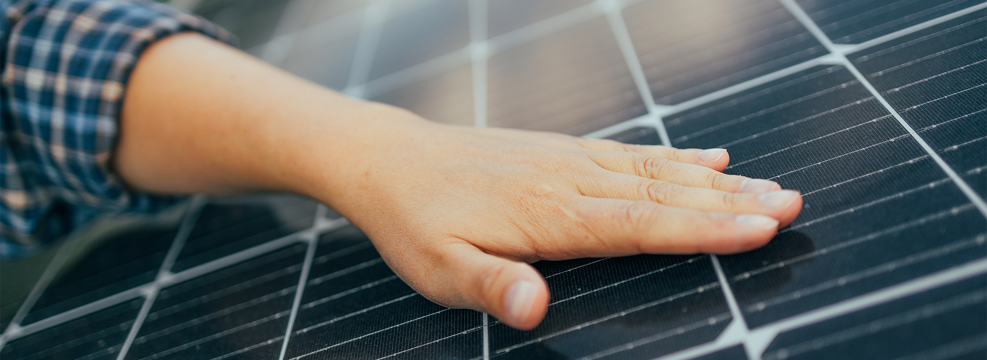Eine Hand, die auf einem Solarpanel liegt