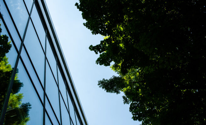 Geb&auml;ude mit Spiegelfenster in der Natur und gr&uuml;ne B&auml;ume