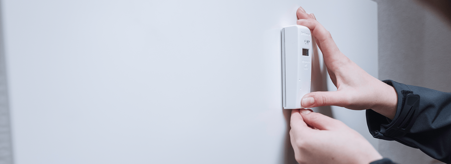 Ein Heizkostenverteiler wird an einer Heizung montiert.