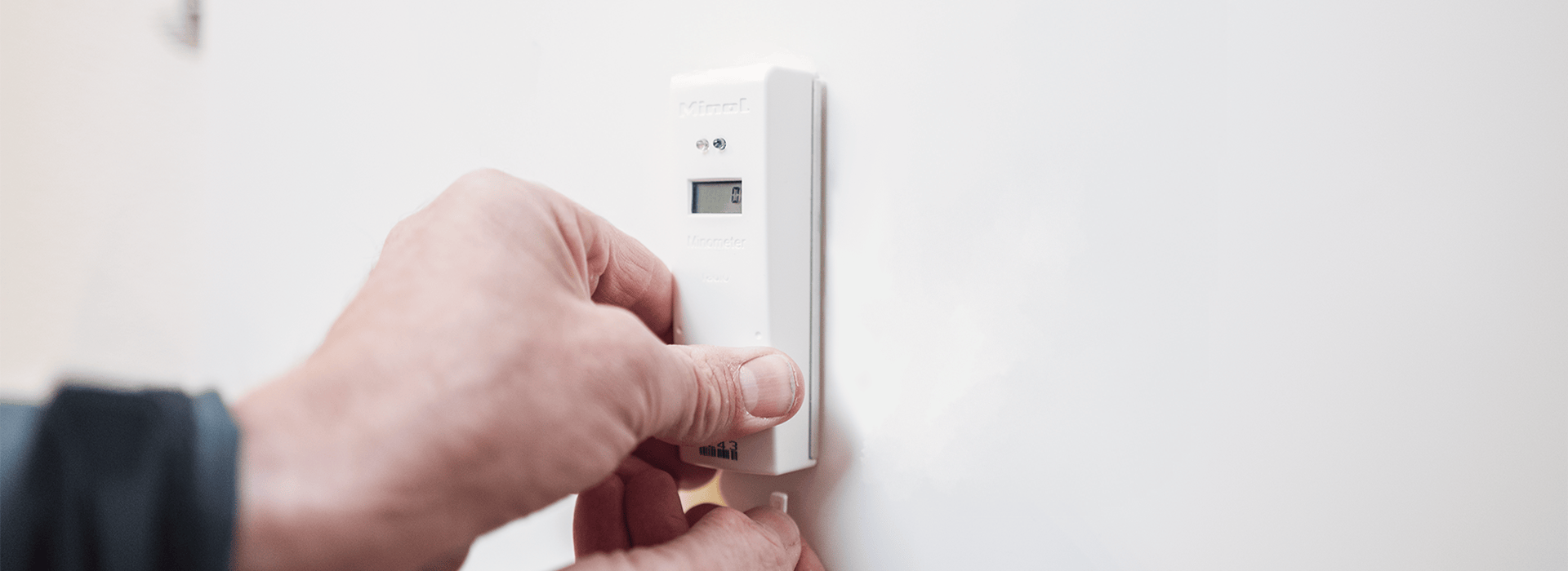 Ein Heizkostenverteiler wird an einer Heizung montiert.