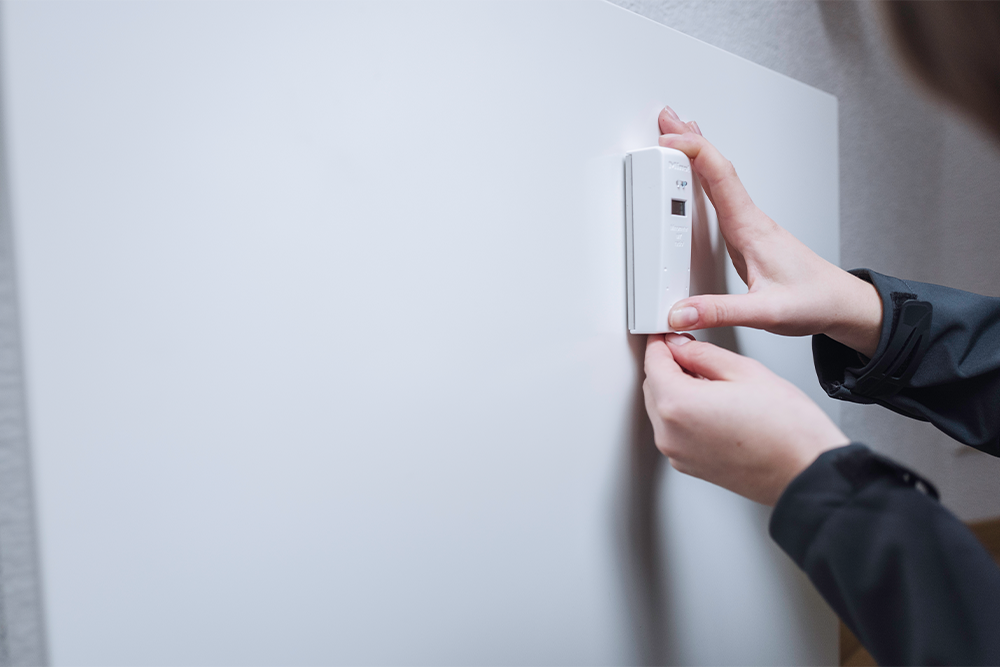 Ein Heizkostenverteiler wird an einer Heizung montiert.