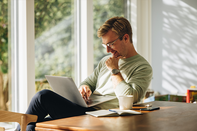 Mann sitzt am Computer und sieht seine Modernisierungsoptionen an