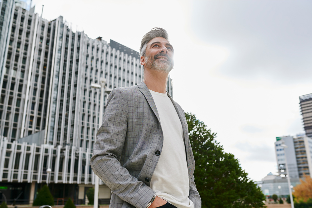 Immobilienservices. Mann steht vor einem Mehrparteiengebäude