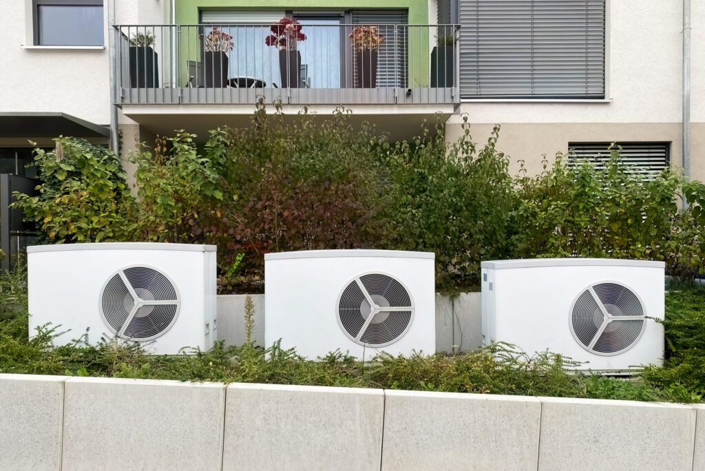 W&auml;rmepumpen vor einem Mehrfamilienhaus