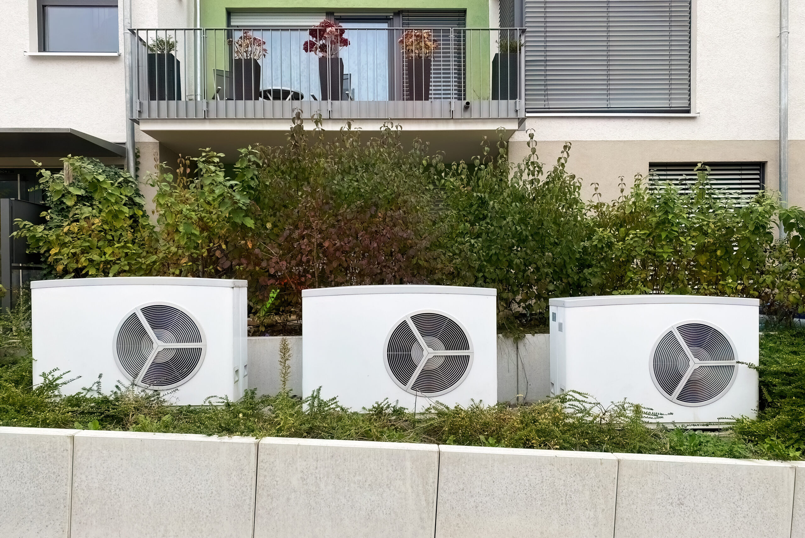 W&auml;rmepumpen vor einem Mehrfamilienhaus