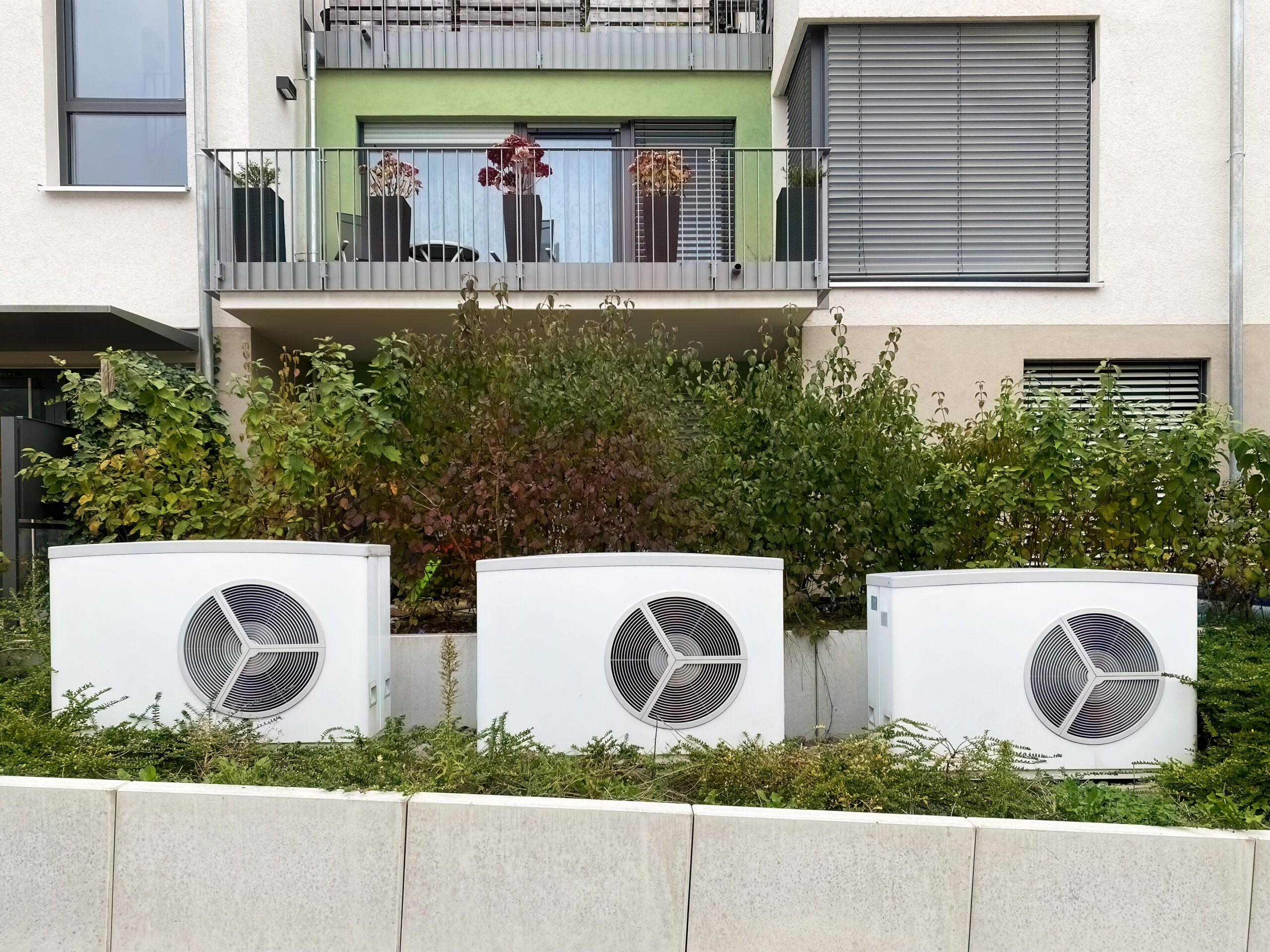 W&auml;rmepumpen vor einem Mehrfamilienhaus